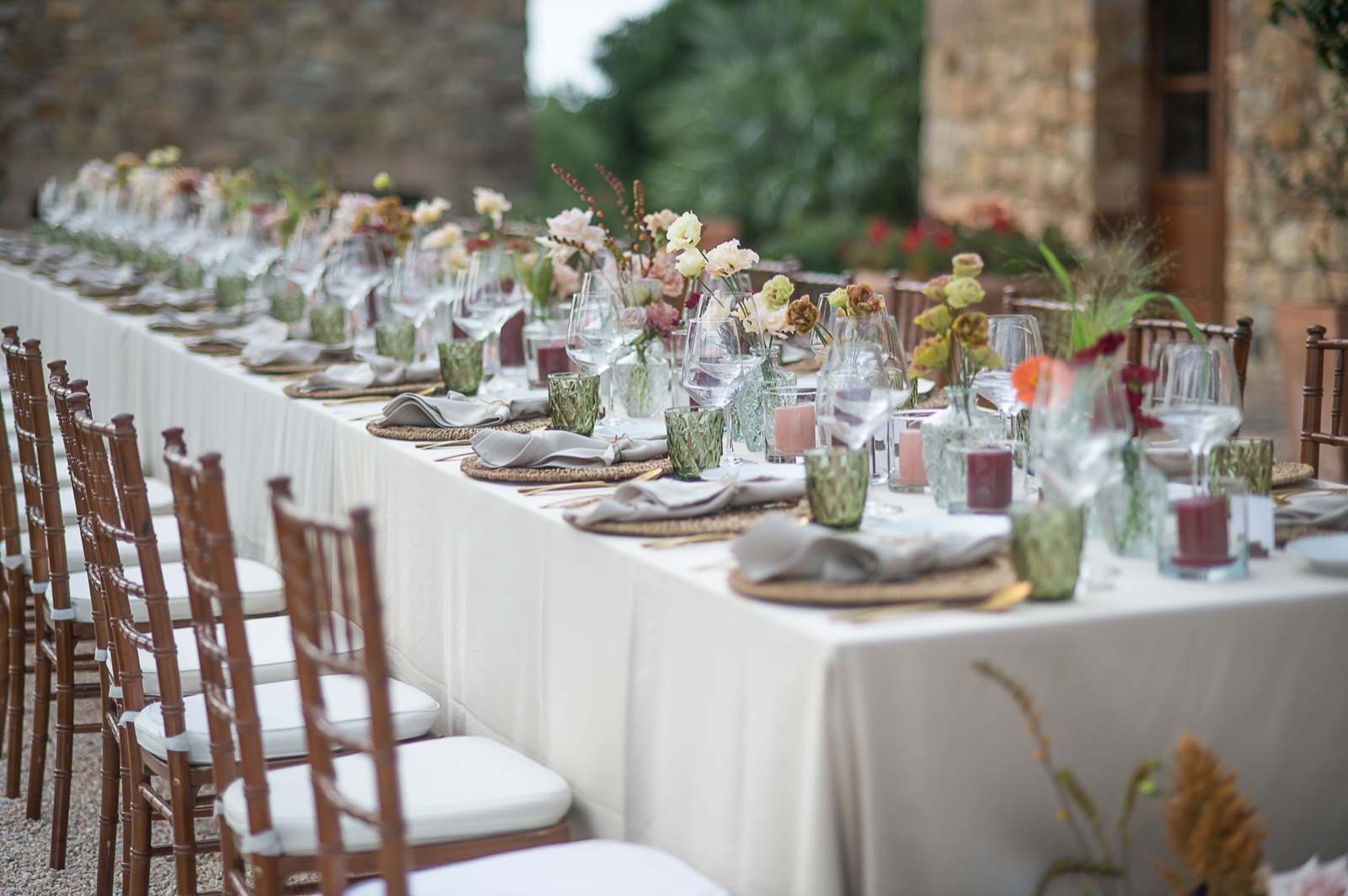 Hochzeitstafel mit Blumenschmuck vor einer toskanischen Steinvilla, vorbereitet für das Dinner am Hochzeitstag